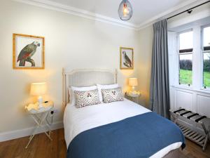 a bedroom with a bed and two lamps and a window at 3 Bed in Lockerbie oc-95861 in Brydekirk