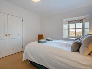 a bedroom with a large white bed with a window at 2 Bed in Biggar oc-95516 in Biggar