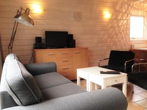 ein Wohnzimmer mit einem Sofa und einem Tisch in der Unterkunft Vakantiehuis in het centrum van Domburg in Domburg