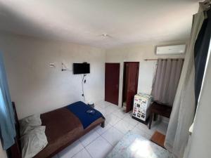 a bedroom with a bed and a television in it at Carpe Diem Suítes in Belém +9 photos