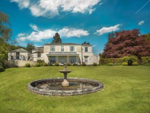 a large white house with a fountain in the yard at 1 Bed in Spark Bridge oc-lcc52 in Spark Bridge