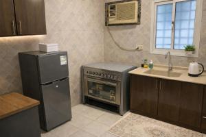 a kitchen with a refrigerator and a stove and a sink at RUBA apartment in Dammam