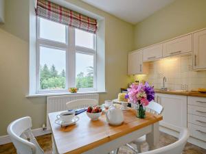 a kitchen with a table with a vase of flowers on it at 2 Bed in Langholm oc-83344 in Langholm +9 photos