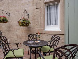 a table with a bottle of wine and chairs on a patio at 2 Bed in Langholm oc-83344 in Langholm