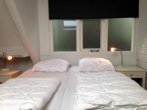 2 Betten in einem Zimmer mit 2 Fenstern in der Unterkunft Vakantiehuis in het centrum van Domburg in Domburg