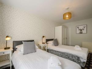 a room with two beds and two tables with lamps at 2 Bed in Sanquhar oc-89403 in Sanquhar