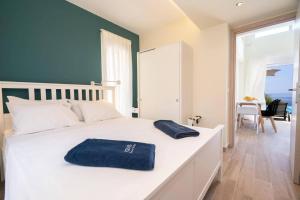 a bedroom with a white bed with blue towels on it at Villa Michou Helios by Villa Plus in Lourdata +19 photos