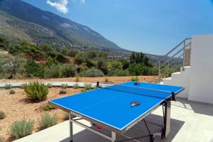 a blue ping pong table with a view of a mountain at Villa Michou Helios by Villa Plus in Lourdata