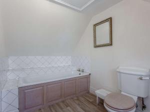 a bathroom with a tub and a toilet and a mirror at 3 Bed in Turriff oc-75489 in Turriff +20 photos