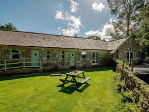 a stone house with a picnic table in the yard at 2 Bed in Sanquhar oc-89402 in Sanquhar