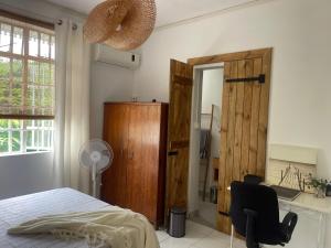 a bedroom with a bed and a chair and a mirror at Studio Evalia in Albion
