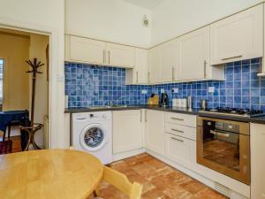a kitchen with white cabinets and a wooden table at 3 Bed in Edinburgh oc-79008 in Edinburgh +13 photos