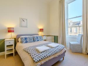 a bedroom with a bed and a chair and a window at 3 Bed in Edinburgh oc-79008 in Edinburgh