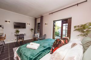 a bedroom with a bed and a living room at Central Stellenbosch Apartment with secure parking in Stellenbosch