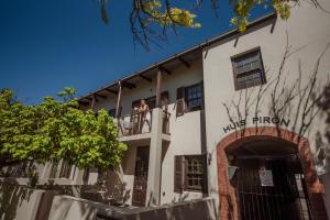 two people on the balcony of a white building at Central Stellenbosch Apartment with secure parking in Stellenbosch