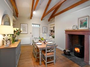 a dining room with a table and a fireplace at 3 Bed in Annan oc-75355 in Annan