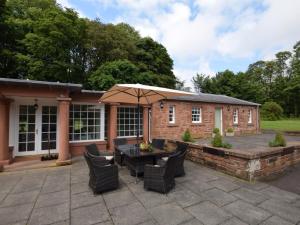 a patio with a table and chairs and an umbrella at 3 Bed in Annan oc-75355 in Annan