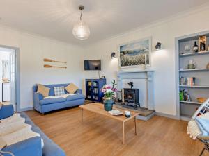 a living room with a blue couch and a fireplace at 3 Bed in Arbroath oc-90784 in Inverkeilor