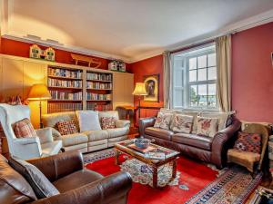 a living room with red walls and leather furniture at 4 Bed in Penrith oc-94247 in Greystoke