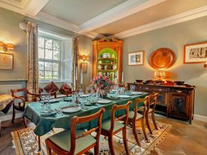a dining room with a green table and chairs at 4 Bed in Penrith oc-94247 in Greystoke