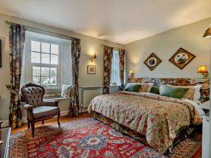 a bedroom with a bed and a chair and a window at 4 Bed in Penrith oc-94247 in Greystoke