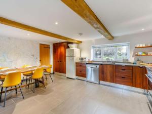 a kitchen with wooden cabinets and a table and chairs at 3 Bed in Wigton oc-86087 in Caldbeck