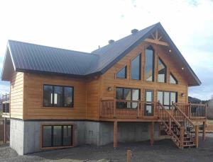 a large wooden house with a large deck at #5 Le Repère Aux Corbeaux in Saint-Onésime