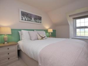 a bedroom with a white bed and a window at 3 Bed in Kirriemuir oc-75284 in Kirriemuir