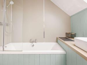 a white bathroom with a tub and a sink at 3 Bed in Kirriemuir oc-75284 in Kirriemuir +25 photos