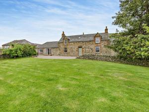 an old stone house with a large grass yard at 3 Bed in Kirriemuir oc-75284 in Kirriemuir