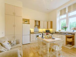 a kitchen with a table and a couch and a table at 1 Bed in Langholm oc-83343 in Langholm +7 photos
