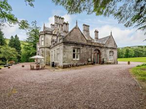 an old stone house with a large driveway at 1 Bed in Langholm oc-83343 in Langholm