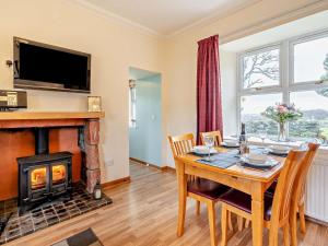 a dining room with a table and a fireplace at 2 Bed in Brechin oc-ca300 in Edzell