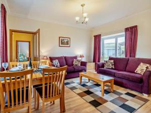 a living room with purple couches and a table at 2 Bed in Brechin oc-ca300 in Edzell