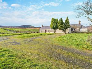 an old house in a field with trees and a road at 2 Bed in Brechin oc-ca300 in Edzell