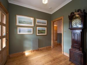 a room with a grandfather clock on a green wall at 3 Bed in Gullane oc-96141 in Gullane