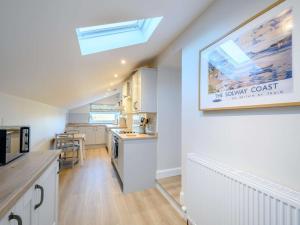 a kitchen with white cabinets and a skylight at 1 Bed in Lockerbie oc-86068 in Lockerbie