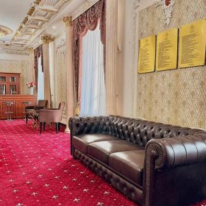 ein Wohnzimmer mit Ledersofa und Klavier in der Unterkunft Lion Hotel in Astana + 250 Fotos