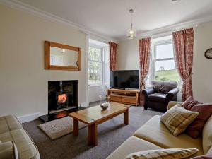 a living room with a couch and a fireplace at 3 Bed in Biggar oc-82924 in Biggar