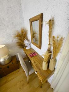 a room with a table with a mirror and a chair at GARDENHILL familly 2 chambres in Argelès-Gazost