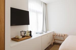 a bedroom with a counter with a tv on the wall at Casa Teva Rooms Sevilla in Seville