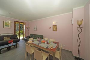 a living room with a table and chairs in a room at Villetta Enzo - Gardagate in Toscolano Maderno