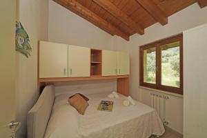 a small bedroom with a bed with a window at Villetta Enzo - Gardagate in Toscolano Maderno +21 photos