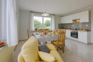 a kitchen and living room with a yellow couch and a table at Apartma pri Cesarjevih in Sežana