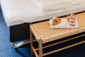 a tray of food sitting on a table next to a bed at Nomad City Hotel - Odense in Odense