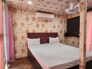 a bedroom with a bed in a pink room at Sheoak Retreat Tajpur in Tajpur
