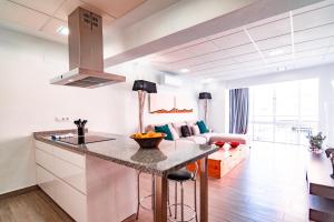 a kitchen and living room with a counter and a couch at EDomus Medellin 1485 Suites in Don Benito