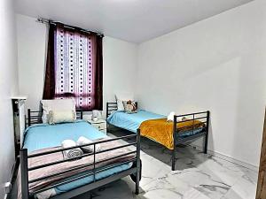 two beds in a room with a window at Paris & Disney - 5 mins from Train Station - Champs Harmony in Champs-sur-Marne