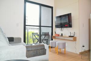a living room with a bed and a tv on a wall at Refugio Premium 2 Quartos 1 Suite WiFi Ar e Garagem in Pelotas