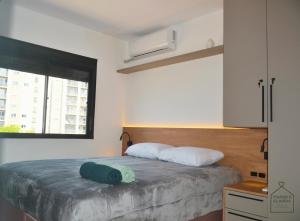 a bedroom with a bed with a green pillow on it at Refugio Premium 2 Quartos 1 Suite WiFi Ar e Garagem in Pelotas